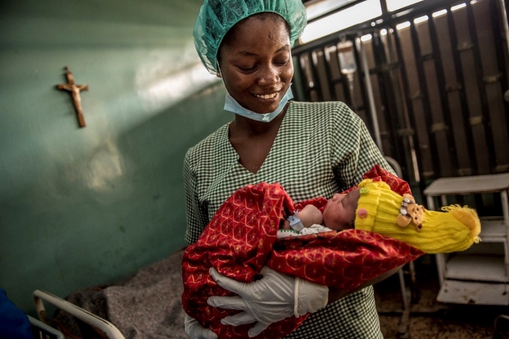 Hospital nurse in Nigeria holds a newborn